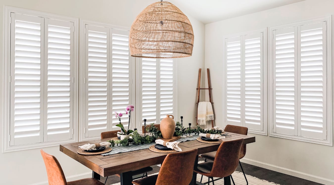 Polywood® shutters are a great option for blocking outside noise. Plantation shutters in a dining room.
